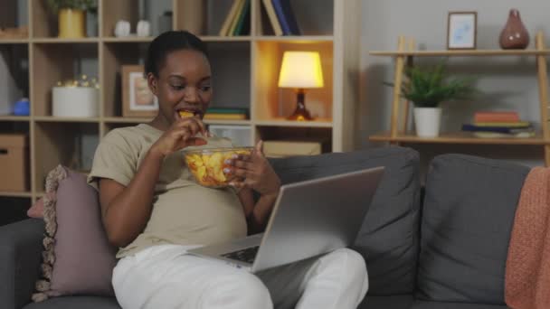 Afrikanisch Amerikanische Werdende Mutter Beim Ungesunden Snack Während Sie Lieblingsprogramme — Stockvideo