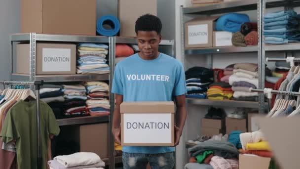 Portrait View Multiracial Volunteer Man Holding Box Clothes Donation Looking — Stockvideo