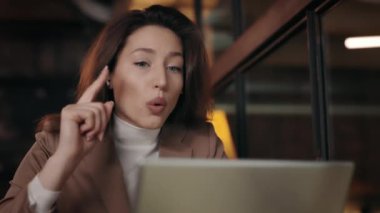 Young business lady discussing project with colleagues on online meetup. Elegant business woman emotionaly gives instructions to subordinates at cafe . Business concept