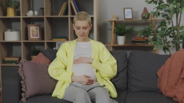 Sonriente Mujer Caucásica Acariciando Vientre Embarazada Mientras Mira Cámara Sala — Vídeos de Stock