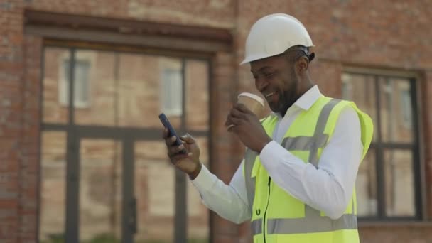 Happy African American Male Builder Using Smartphone Surfing Internet House — Stock Video