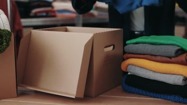 Близько Волонтера Сортують Одяг Пожертвувань Речі Полицях Задньому Плані Концепція — стокове відео