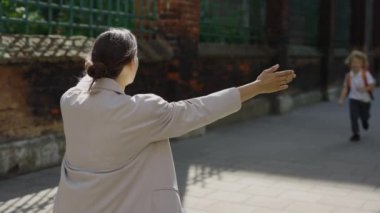 Arkadan bak. Mutlu anne dersten sonra oğluyla sokakta buluşur. Ebeveynler ve çocuklar arasındaki duygusal buluşma