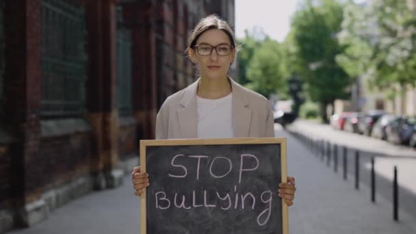 Female Standing Street Looking Camera Protest Bullying Teacher Holding Board — ストック動画