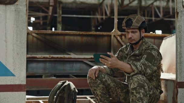 Armádní Voják Sedící Poblíž Zničeného Autobusu Zřícené Budově Používající Mobilní — Stock video