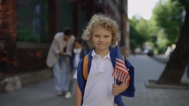 Retrato Niño Parado Afuera Cerca Escuela Con Bandera Americana Niño — Vídeo de stock