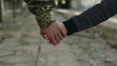 Terk edilmiş fabrikada birlikte yürürken oğlu ve askeri annesinin el ele tutuşması. Askeri görev ve çocukların kurtarılması..