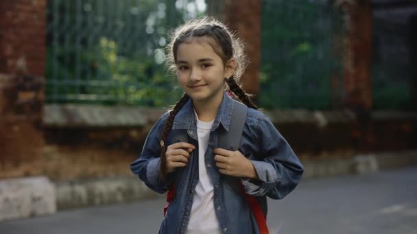 Portrait Little Schoolgirl Standing School Yard Holding Bag Turn Looking — стоковое видео