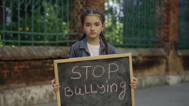 Portrait Upset Little Girl Standing Holding Board Text Message Stop — Stockvideo