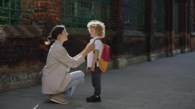 Anne oğlunu sokak çocuğu olarak umursuyor. Komik bir hikaye anlat. Anne gülümseyen bir çocuk, duygusal olarak dışarıda konuşuyor.
