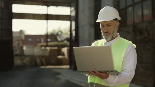 Professional Male Architect Helmet Vest Using Wireless Laptop Improving Blueprints — Stock Video