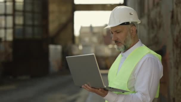 Senior Foreman Protective Hardhat Looking Laptop Talking Walkie Talkie Concentrated — Stock Video