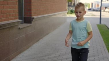 Little boy is holding the glass bottle and puts it to the correct bin for glass. Kid learning how to sorting garbage. Ecology and environmental problems concept