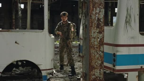 Συγκεντρωμένος Στρατιώτης Τουφέκι Ελεύθερου Σκοπευτή Ανάμεσα Κατεστραμμένα Λεωφορεία Εγκαταλελειμμένο Εργοστάσιο — Αρχείο Βίντεο
