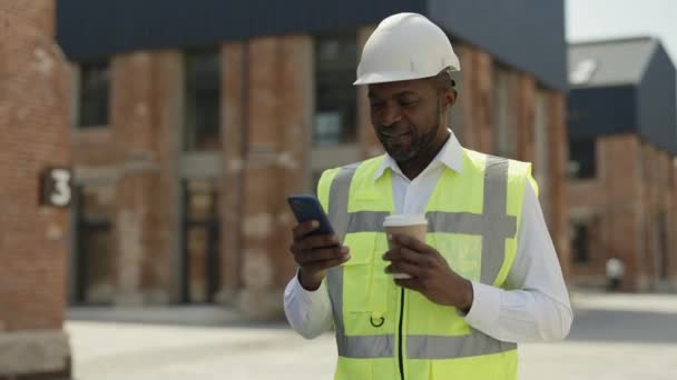 Smiling African American Architect Uniform Drinking Coffee Using Smartphone While — Stock Video