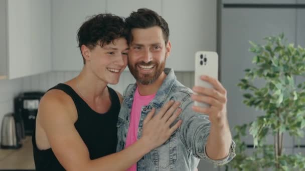 Lgbt gays smiling couple is making a selfie with smartphone at home. Technology and relationship concept