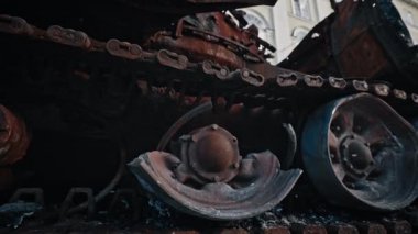 Caterpillar and wheels track of burned-out Russian tank. Close up. soldier hand touches a tank track. Military battle army war concept