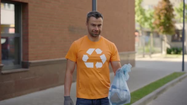Άνδρας Εθελοντής Στέκεται Και Κρατώντας Μια Μπάλα Ταξινομημένα Σκουπίδια Φορώντας — Αρχείο Βίντεο