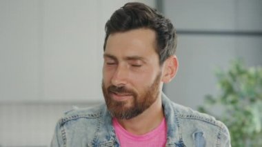 Close view of the smiled man looking at the camera. Portrait of the handsome middle aged gay standin on the kitchen at home. People concept
