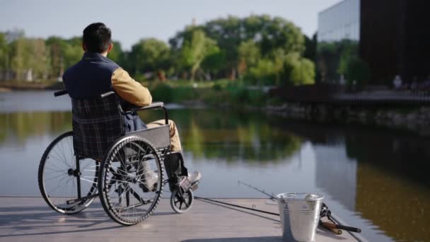 Πίσω Όψη Του Ανάπηρου Ψαρά Που Κάθεται Στην Αναπηρική Καρέκλα — Αρχείο Βίντεο