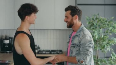 Gay couple in love at home dancing and hugging feeling happy in love together. Romantic Lgbt family having fun at home spending time together . People relationship concep