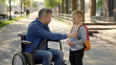 Disabled father tells his son a story and takes five with his son and son goes to school. Education time. amily and disabled people concept