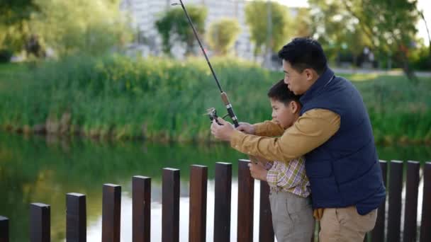 Asian Dad Shows His Son How Cast Fishing Rod Practice — Vídeo de stock