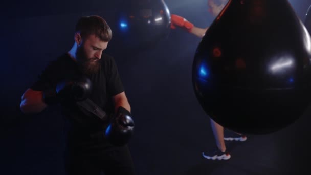 Male Boxer Wearing Boxing Gloves Training Woman Punching Boxing Bag — Stock Video