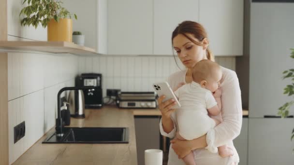 Anxious Mother Using Smartphone Phone Looking Back Baby She Holding — Wideo stockowe