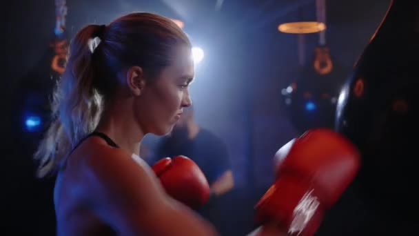 Vista Lateral Cerca Mujer Fuerte Está Perforando Bolsa Boxeo Boxeadora — Vídeos de Stock