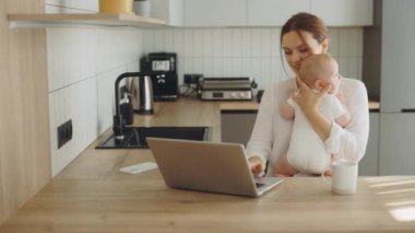 Kafkasyalı mutlu anne bebeği kucağında tutuyor ailesiyle ya da arkadaşlarıyla görüntülü görüşme yapıyor ve yeni doğan bebeğe gösteriyor. Teknoloji ve annelik kavramı