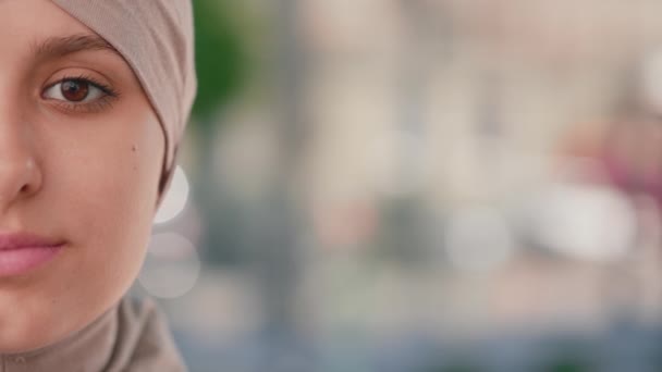 在室外用褐色头巾把穆斯林妇女的半张女性脸围起来 色彩艳丽的阿拉伯妇女 有着天然的妆容 头戴头巾凝视着相机的安详女士的头像 — 图库视频影像