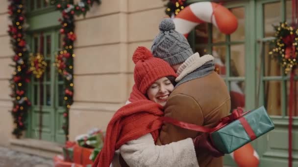 素敵なカップルは お互いにクリスマスの贈り物を与え 幸せと愛を感じて通りで抱き合っています 関係と休日の概念 — ストック動画