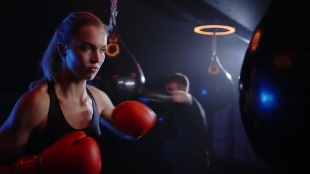 Strong Woman Punching Boxing Bag Wearing Red Gloves Man Training — Stock Video