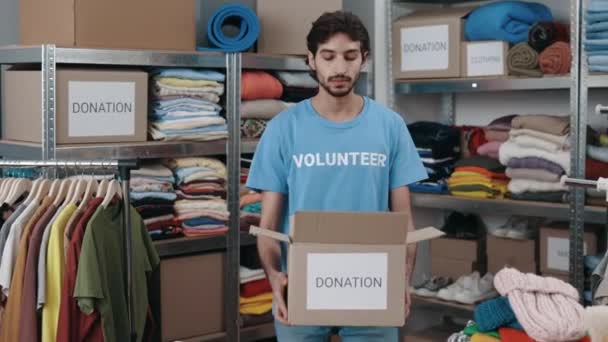 Homem Voluntário Caucasiano Segurando Caixa Com Roupas Para Doação Classificação — Vídeo de Stock