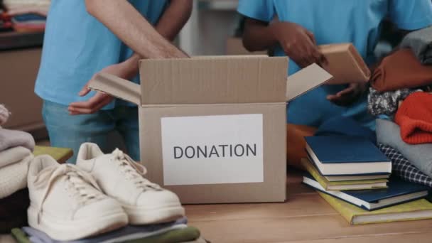 Male Female Volunteers Hands Sorting Books Putting Cupboard Box Warehouse — Stock Video