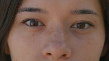 Kadın yüzüne yakın, kadın güzel kahverengi gözlerini açıyor, çekici Asyalı kadın. Çilli doğal bir güzellik. Uzun kirpikleri ve çekici görünüşü olan muhteşem bir kadın. Yavaş çekim