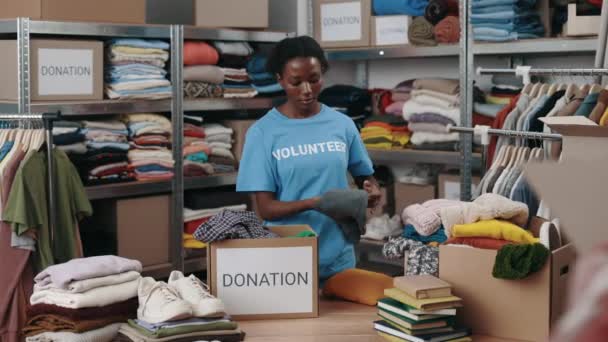Volontaire Femme Debout Entrepôt Tout Triant Itérant Des Vêtements Pour — Video