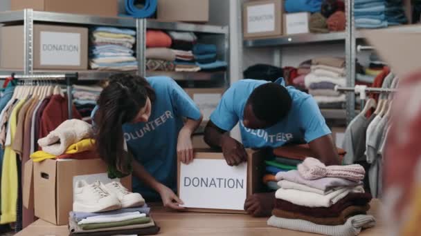 Різноманітні Добровольці Розміщують Папір Пожертвувальним Словом Коробці Благодійному Центрі Громади — стокове відео