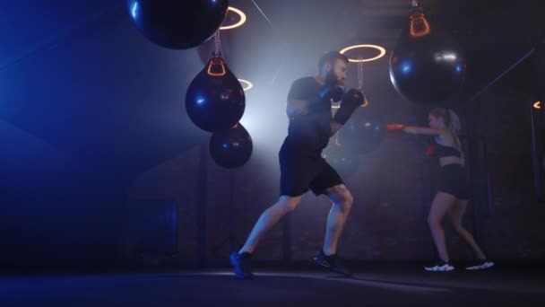 Male Boxer Showing Pugilism Hitting Boxing Bag Woman Training Background — Stock Video