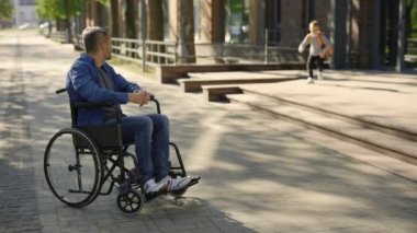 Engelli baba oğlunu okuldan bekliyor. Engelli babasına sarılmak için okuldan kaçan mutlu çocuk. Aile ve engelliler kavramı