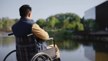 Rıhtımdaki engelli adamın sabahın erken saatlerinde tek başına gölde denize baktığı görüntüler. İnsanlar, rehabilitasyon ve dinlenme konsepti