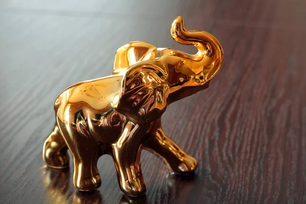 Masanın üzerinde duran bir fil heykeli.