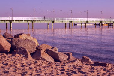 Sahilde gün batımı iskeleye bakıyor.
