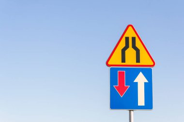 Mavi gökyüzüne karşı yol işaretleri