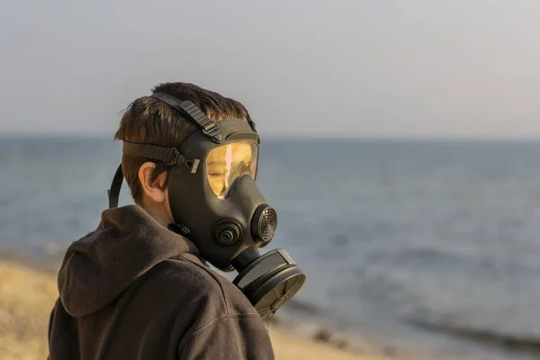 Yüzünde gaz maskesi olan bir çocuk.