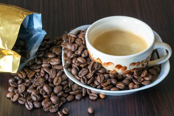 Een Kopje Koffie Met Koffiebonen Besprenkeld Uit Een Zak — Stockfoto