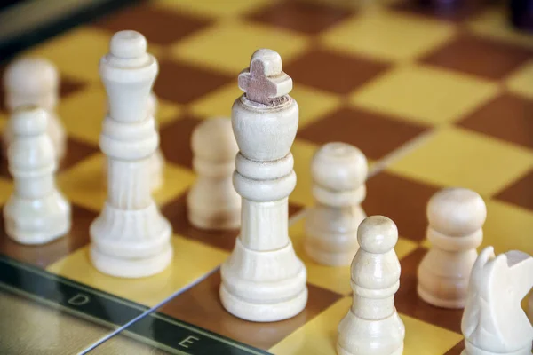 Beyaz satranç taşları tahtada duruyor ve oynamaya hazır.