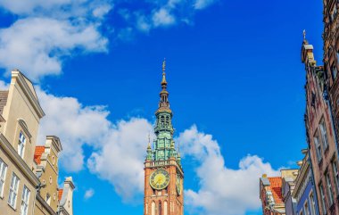 Saat kulesi Polonya 'nın Gdansk şehrinde gökyüzüne karşı apartmanlarla çevrili.