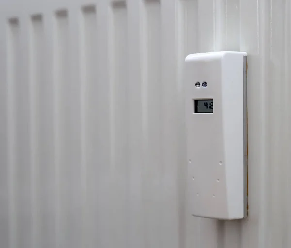 White heat meter hanging on the radiator in Poland